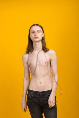Androgynous güzel genç adam. Sarı arkaplanda model testleri