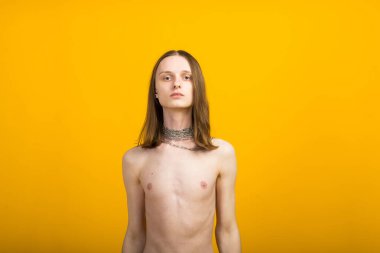 Androgynous güzel genç adam. Sarı arkaplanda model testleri