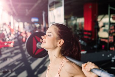 Spor giyimli atletik kız halterle, halterle egzersiz yapıyor. Fitness, egzersiz, sağlıklı yaşam tarzı