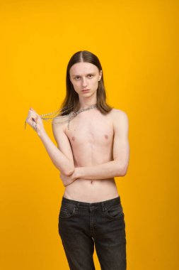 Androgynous güzel genç adam. Sarı arkaplanda model testleri