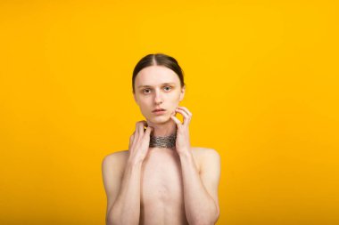 Androgynous güzel genç adam. Sarı arkaplanda model testleri