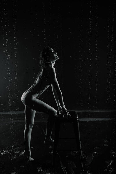 Young woman with beautiful sportive body in perfect shape with water drops in white lingerie in aquastudio