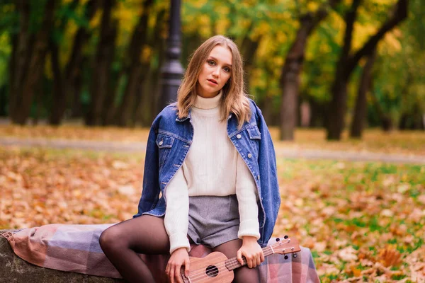 Una Mujer Joven Está Sentada Banco Parque Jugando Ukelele Posando —  Fotos de Stock