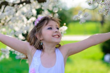 Güzel bir bahar gününde, çiçek açan elma bahçesinde güzel bir kız.