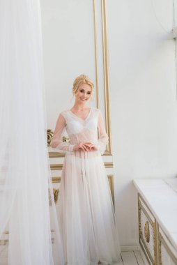 Kavramsal düğün, gelinin Avrupa tarzında bir sabah. İç stüdyoda özel bir elbise var. Gelin için beyaz minimalizm
