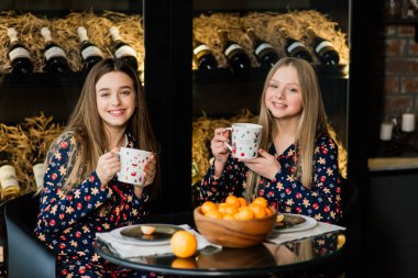 Yeni yıl arifesini ve Noel 'i kutlayan ve yatakta mandalina yiyen kızlar. Hediyeler ve altın toplarla süslenmiş köknar dalları var..