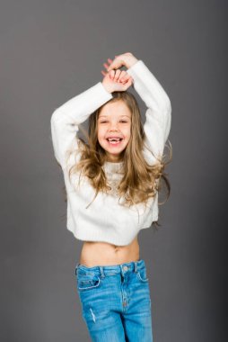 Gri üzerinde izole edilmiş güzel, neşeli ve kendinden emin bir kızın portresi.