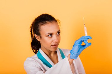 Sarı arka planda izole edilmiş güzel Afrikalı Amerikalı doktor ya da hemşire portresi