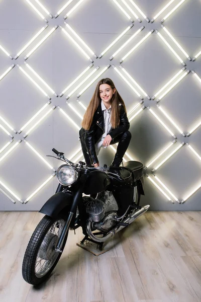 若いですファッション女の子ポーズで黒革とともにオートバイ — ストック写真