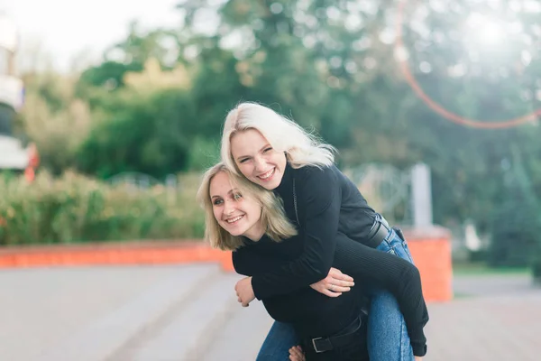 Twee Jonge Vrouwen Wandelen Glimlachend Omhelzen Kussen Outdoor — Stockfoto