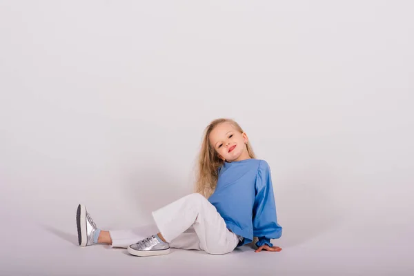 Mała Blondynka Śmieje Się Siedzi Podłodze Udaje Samotną Niebiesko Dzieciństwo — Zdjęcie stockowe