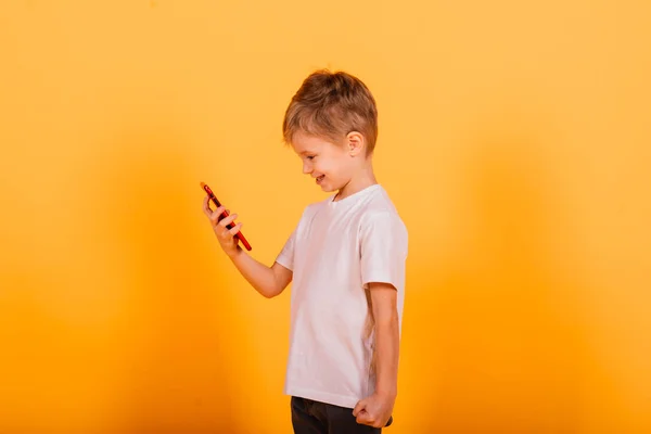 Menino Feliz Falando Telefone Celular Sobre Fundo Amarelo Estúdio — Fotografia de Stock