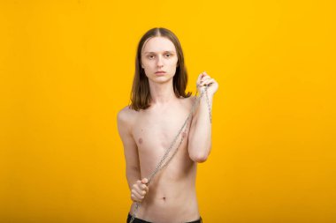 Metal zincirli genç bir kadın. İnce vücut, çift cinsiyetli.