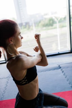 Spor salonunda halterli genç ve güzel bir bayan antrenman yapıyor. Eğitim için elementlerle poz vermek