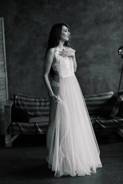 Beyaz iç çamaşırlı güzel gelin yatak odasında ve stüdyosunda oturuyor. Düğün konseptinin sabahı