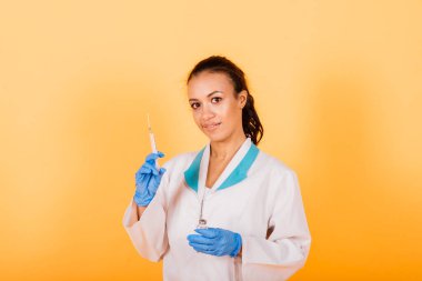 Afro-Amerikalı doktor kadın, maske, stetoskope, bornoz aşısı stüdyoda.