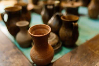 El yapımı çömlek testisi. Çömlek atölyesinde ateş etmeden önce el işi kil kahverengi sofra takımı, toprak kapları. Seramik ürün konsepti.