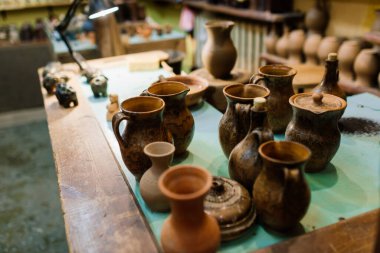 El yapımı çömlek testisi. Çömlek atölyesinde ateş etmeden önce el işi kil kahverengi sofra takımı, toprak kapları. Seramik ürün konsepti.