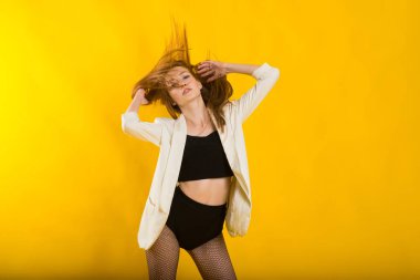 Ekose ceketli, beyaz benekli tayt ve çizmeli güzel bir kadının stüdyo portresi.