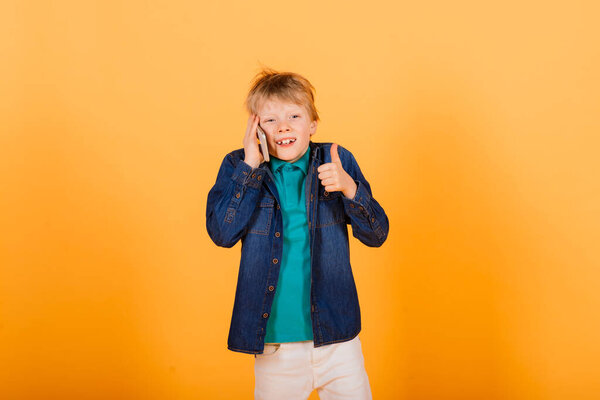 Маленький мальчик телефоны на желтом фоне