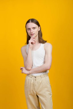 Androgynous güzel genç adam. Sarı arkaplanda model testleri