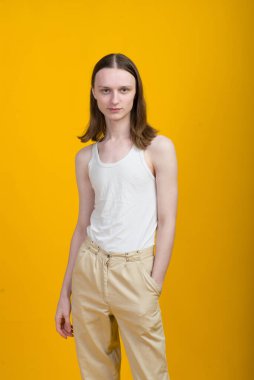 Androgynous güzel genç adam. Sarı arkaplanda model testleri