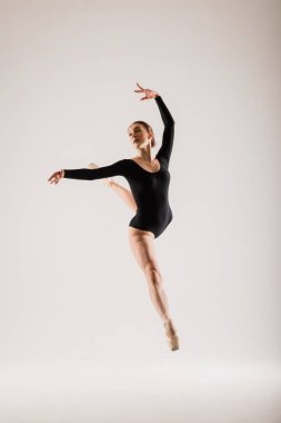 Beyaz takım elbiseli beyaz tenli beyaz dansçı portariti ve beyaz zeminde poz veren ayakkabılar..