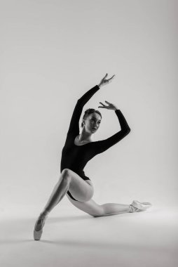 Beyaz takım elbiseli beyaz tenli beyaz dansçı portariti ve beyaz zeminde poz veren ayakkabılar..