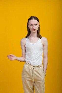 Androgynous güzel genç adam. Sarı arkaplanda model testleri