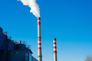 Endüstriyel üretim bölgesinde yüksek fabrika yapısı ve kule vinci, mavi gökyüzü