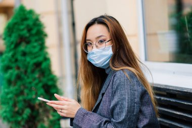 Grip virüsü grip virüslerine ve hastalıklara karşı koruyucu maske yayıyor. Halka açık yerlerde cerrahi maske takan Asyalı bir kadın. Sağlık Hizmetleri.