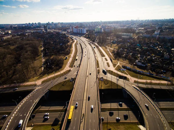 Aerial view at junctions of city highway. Vehicles drive on roads. Belarus, Russia