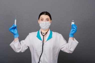Şırıngalı bir bilim adamı klinik deneye hazır olması için bir araştırma aşısında virüsü analiz ediyor..