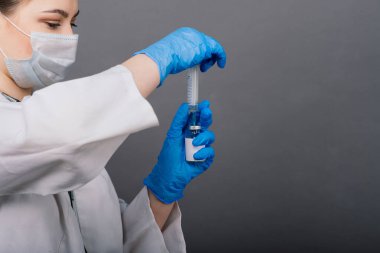 Şırıngalı bir bilim adamı klinik deneye hazır olması için bir araştırma aşısında virüsü analiz ediyor..