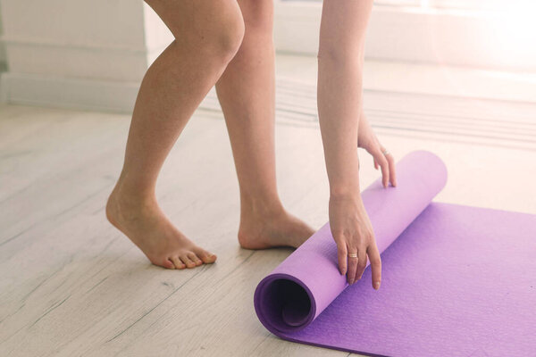 Молодая привлекательная улыбающаяся женщина практикующая йогу, тренирующаяся, носящая спортивную одежду, лифчик, домашнюю тренировку