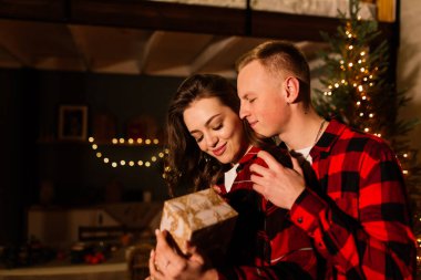 Aşk, Noel, çift, evlenme teklifi. Mutlu adam evdeki kadına elmas nişan yüzüğü veriyor.