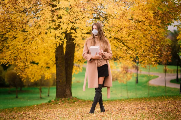 가을을 배경으로 의료용 마스크를 아름다운 여성의 — 스톡 사진
