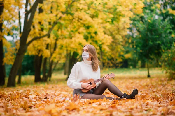 Retrato Mujer Joven Máscara Protectora Tocando Guitarra Ukelele Parque Otoño — Foto de Stock
