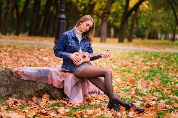 Una Mujer Joven Está Sentada Banco Parque Jugando Ukelele Posando — Foto de Stock