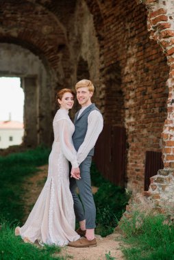 Çok hoş kızıl saçlı genç evli mutlu bir çift gün batımında dışarıda öpüşüyor.