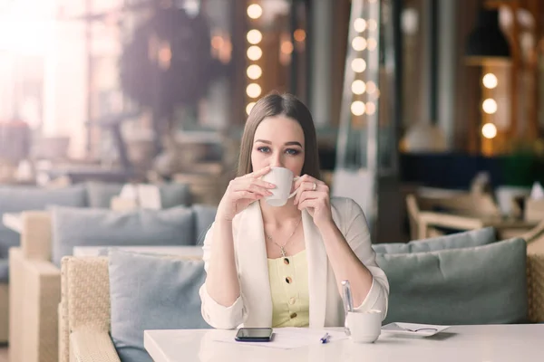 Mujer Joven Una Chaqueta Blanca Trabajando Cafetería Con Papeles Bebiendo — Foto de Stock