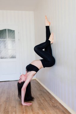 Formda ve sağlıklı kalmak. Spor kıyafetleri içinde güzel bir kadın evde dinlenirken yoga yapıyor.