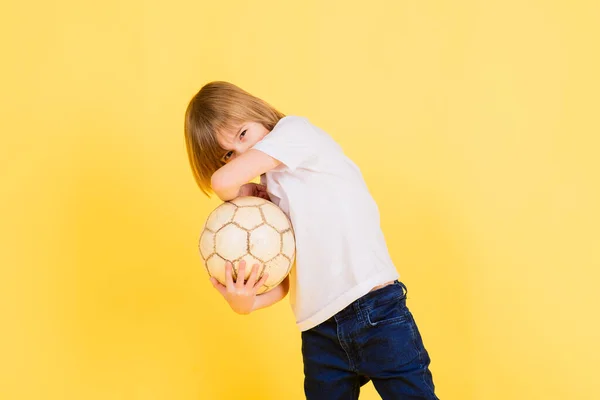 Симпатичный Мальчик Держит Футбольный Мяч Натуральной Кожи Желтом Фоне Футбол — стоковое фото