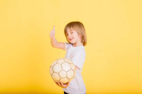 Cute Boy Trzyma Piłkę Nożną Prawdziwej Skóry Izolowane Żółtym Tle — Zdjęcie stockowe