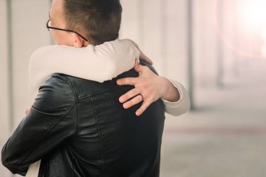 Şehirdeki sevimli eşcinsel çift, şefkatle öpüşüyor, gülümsüyor.