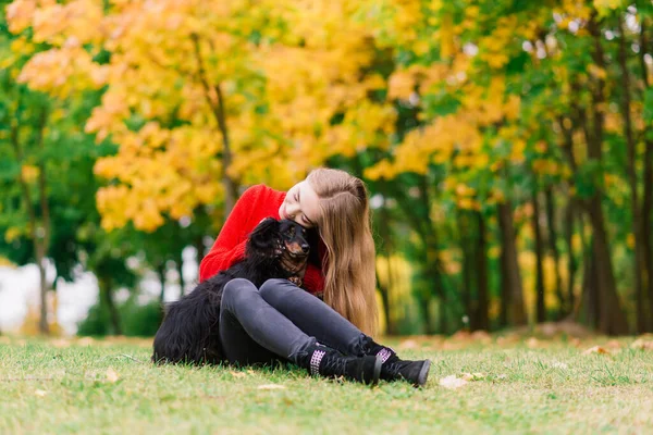 快乐的女人抱着她的小狗 秋天的公园 — 图库照片