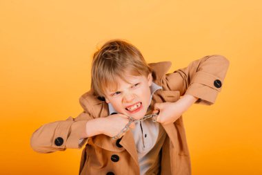 Sarı bir stüdyoda poz veren asık suratlı, duygusal, kızıl saçlı çocuk.