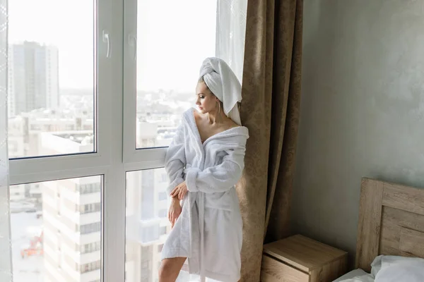 Mulher Roupão Branco Ficar Perto Janela Uma Cama Quarto Hotel — Fotografia de Stock