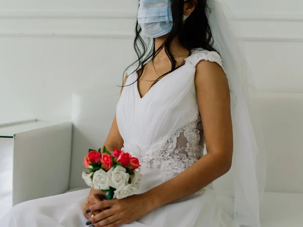African American bride in dress, mask and in morning preparing for the wedding in hotel room