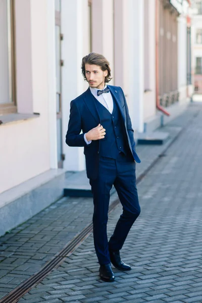 上品なスーツに身を包んだハンサムなファッションビジネスマンモデルと路上でポーズ メトロセクシャル — ストック写真